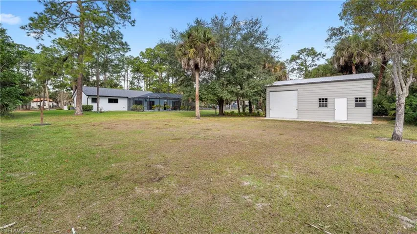View of green lawn featuring an outdoor structure