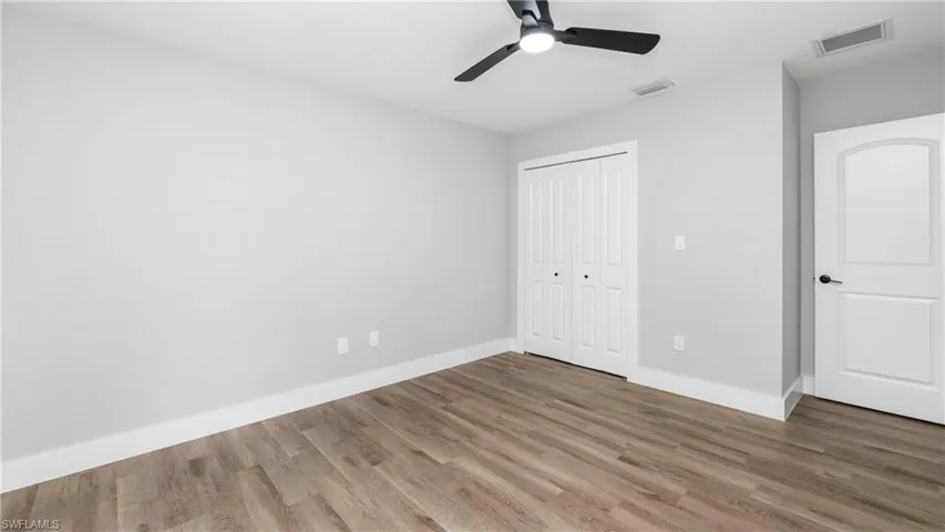 Unfurnished bedroom featuring a closet, light wood-style floors, and ceiling fan