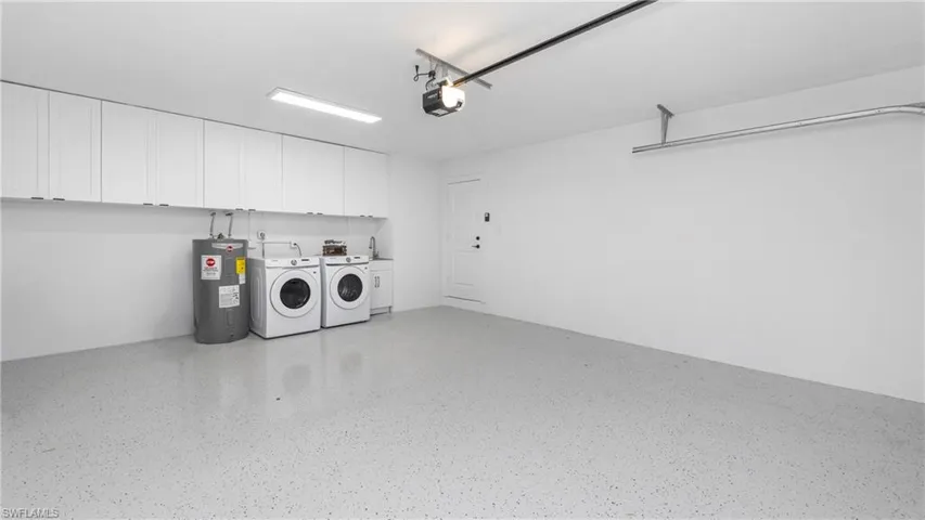Garage with water heater, washing machine and dryer, and a garage door opener