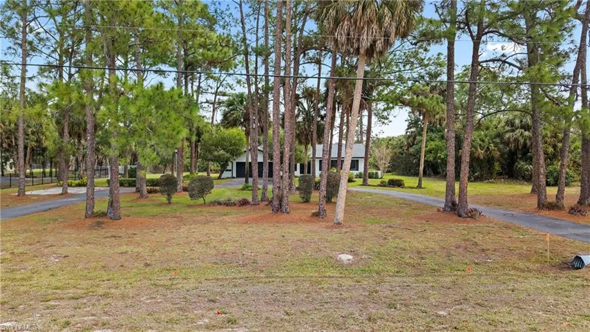 View of front of home with a front yard and asphalt driveway