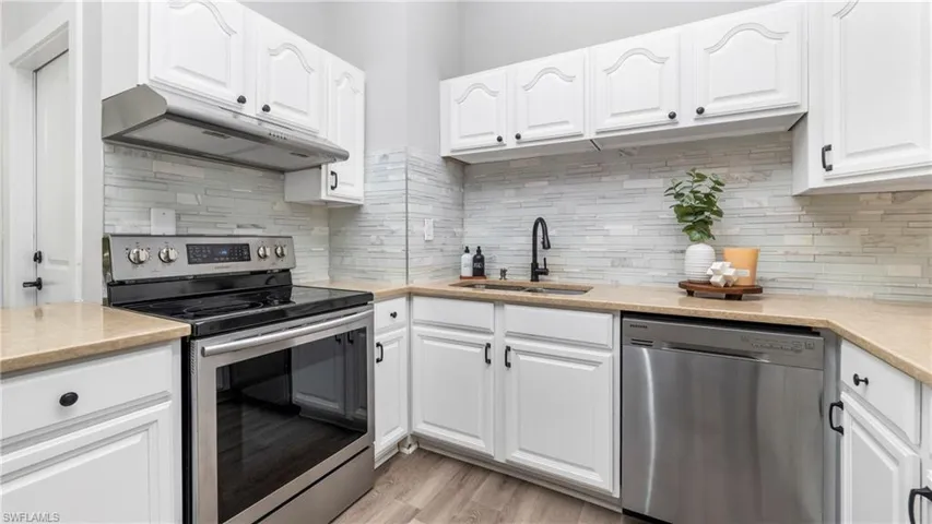 Kitchen featuring appliances with stainless steel finishes, white cabinetry, and under cabinet range hood