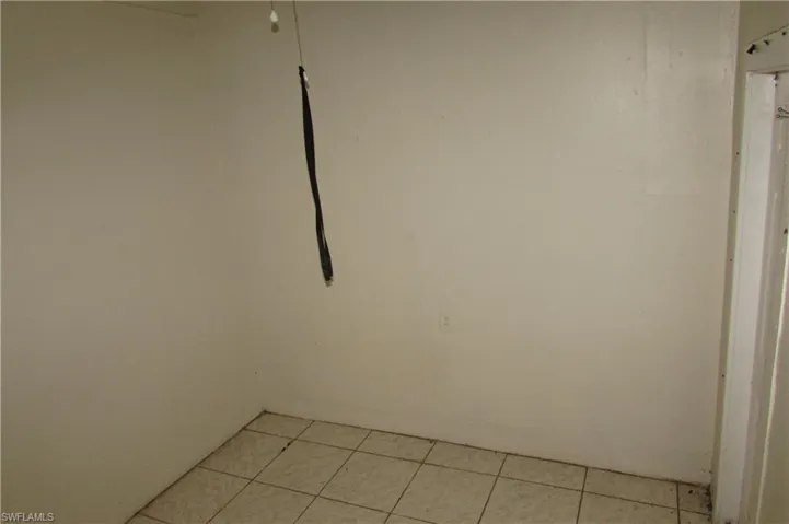 Empty room with light tile patterned flooring