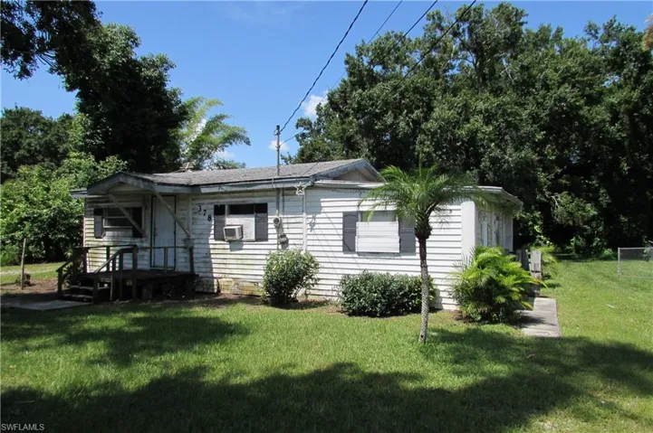 View of front of property featuring a front lawn and cooling unit
