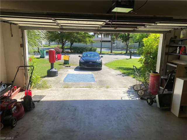 Garage featuring a lawn and a garage door opener