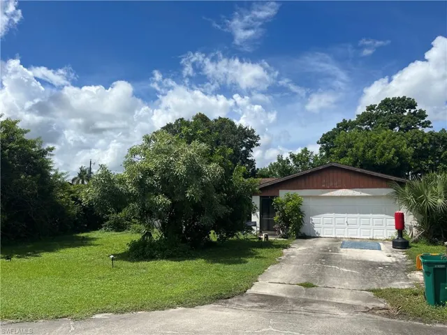 View of front facade with a garage and a front lawn