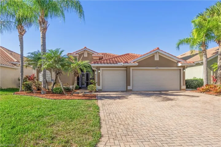 Mediterranean / spanish-style house featuring stucco siding, decorative driveway, an attached garage, a front yard, and a tile roof