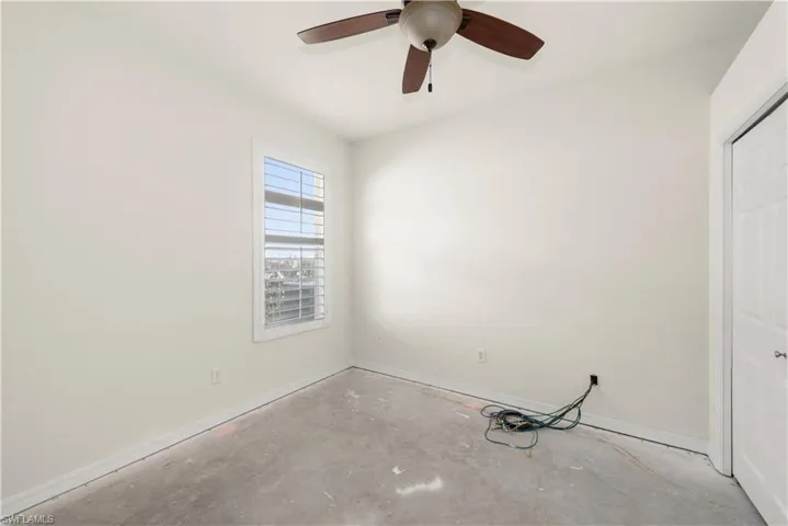 Unfurnished bedroom with a closet, ceiling fan, and unfinished concrete floors