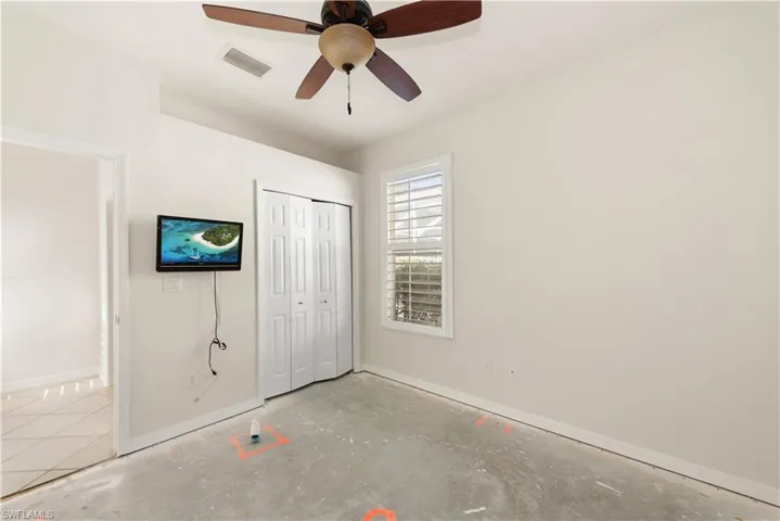Unfurnished bedroom with a ceiling fan, a closet, and concrete floors
