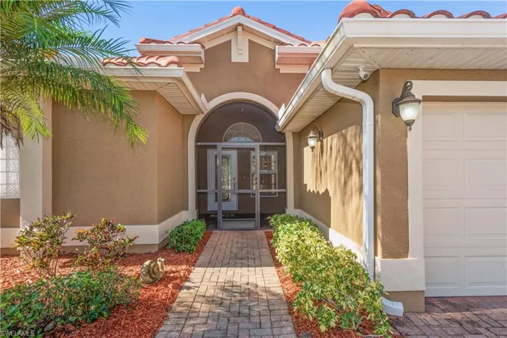 Doorway to property with stucco siding, a tile roof, and french doors