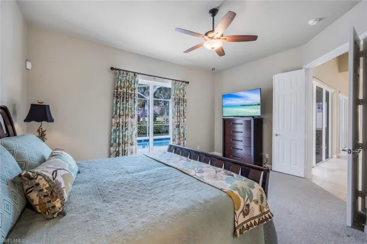 Carpeted bedroom with ceiling fan and access to exterior