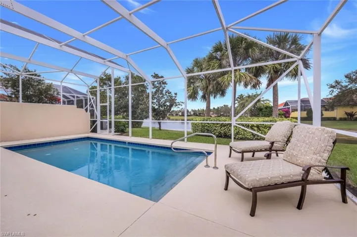 View of swimming pool with a patio area and glass enclosure