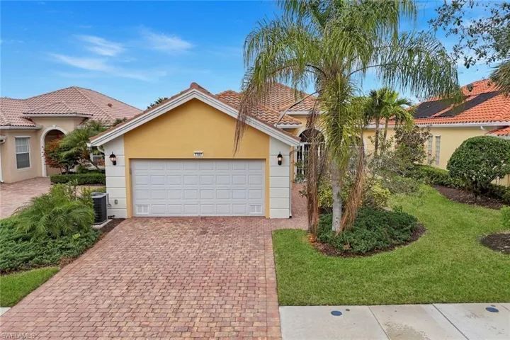 Mediterranean / spanish-style house featuring a garage, a front lawn, and central AC unit