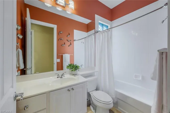 Full bathroom featuring toilet, vanity, and shower / tub combo with curtain