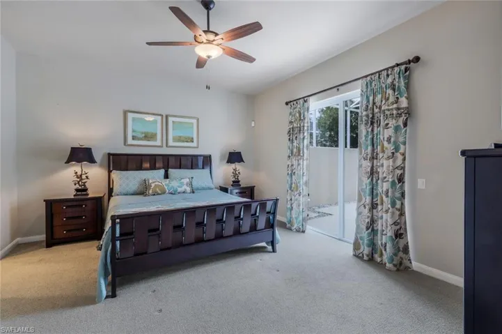 Bedroom featuring ceiling fan, light carpet, and access to outside