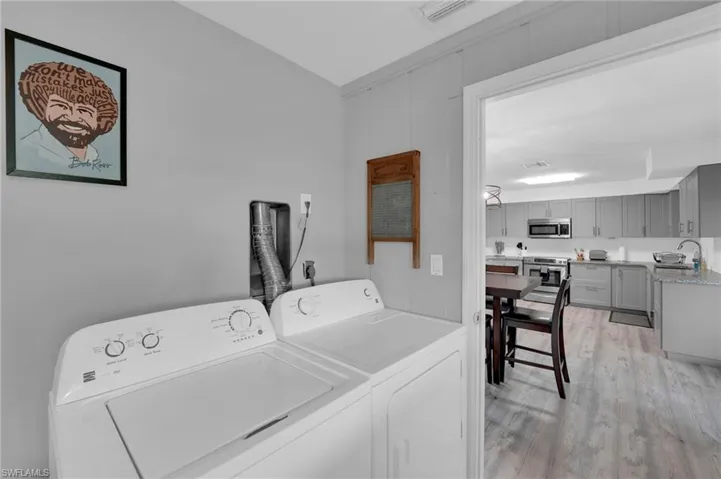 Laundry area with light wood-style flooring and separate washer and dryer