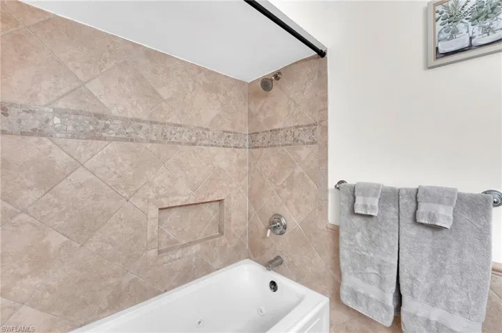 Full bath featuring a combined bath / shower with jetted tub