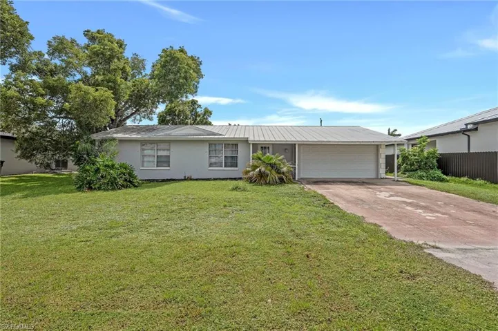 Ranch-style home with a metal roof and a 2 car garage.