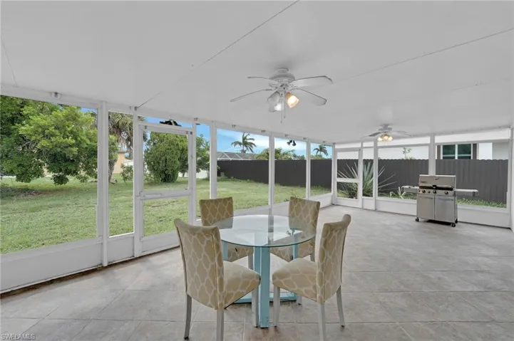 Sunroom / solarium with ceiling fan and outdoor dining area