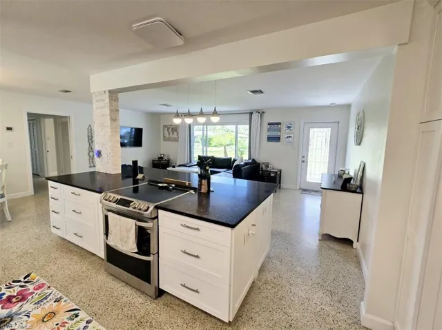 Kitchen with pendant lighting, white cabinets, a kitchen island, and range with two ovens