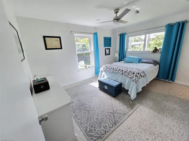Bedroom featuring ceiling fan and multiple windows
