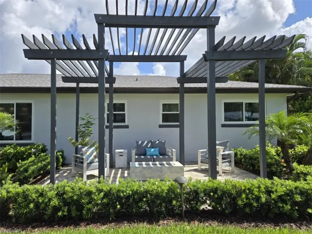 Rear view of house featuring a pergola, an outdoor hangout area, and a patio