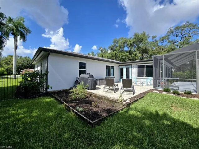 Back of property featuring a lawn and a patio area
