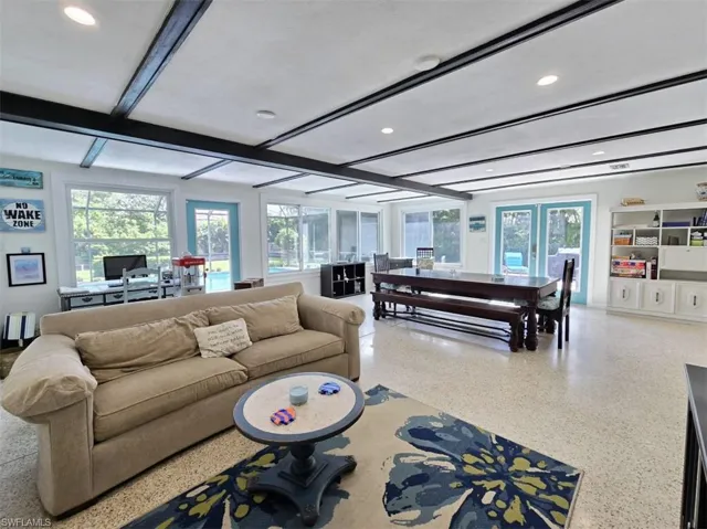 Living room with beam ceiling and french doors