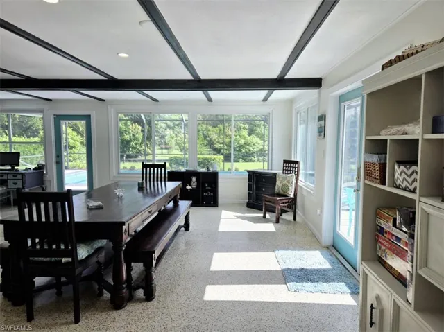 Carpeted dining room featuring beamed ceiling