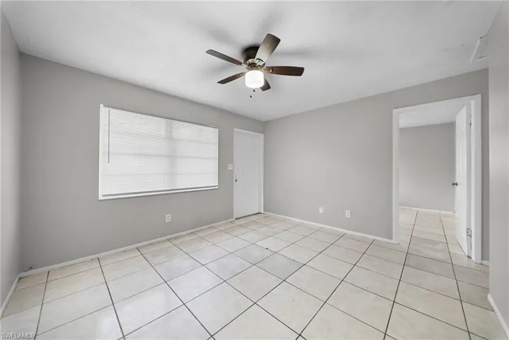 Spare room with ceiling fan and light tile patterned floors