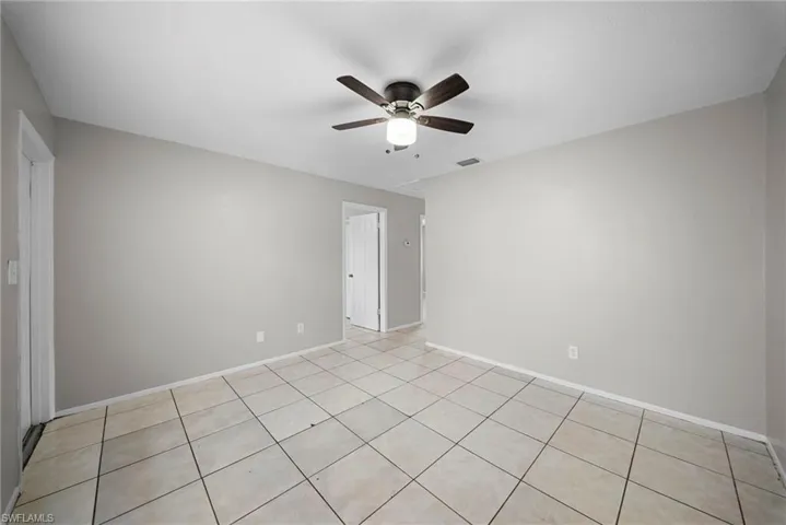 Empty room featuring a ceiling fan and light tile patterned flooring