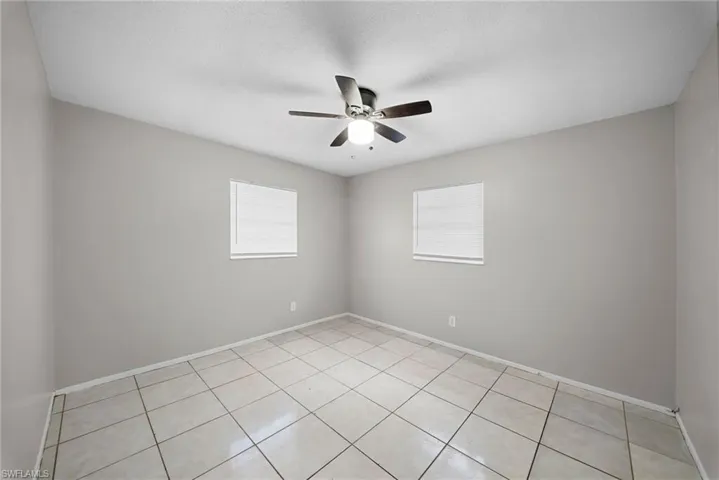 Spare room with ceiling fan and light tile patterned floors