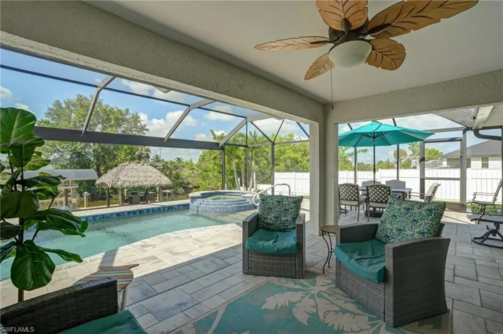 View of patio / terrace with a pool with connected hot tub, a gazebo, a ceiling fan, and glass enclosure