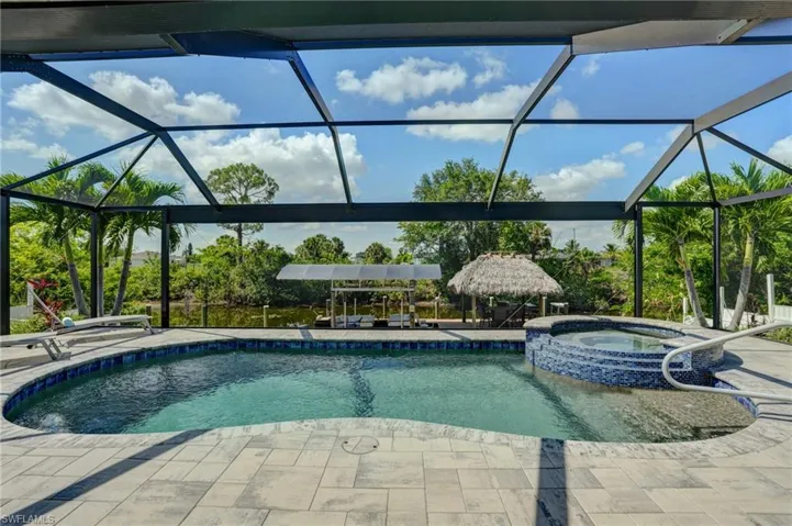 View of swimming pool featuring a patio area, a lanai, and a pool with connected hot tub