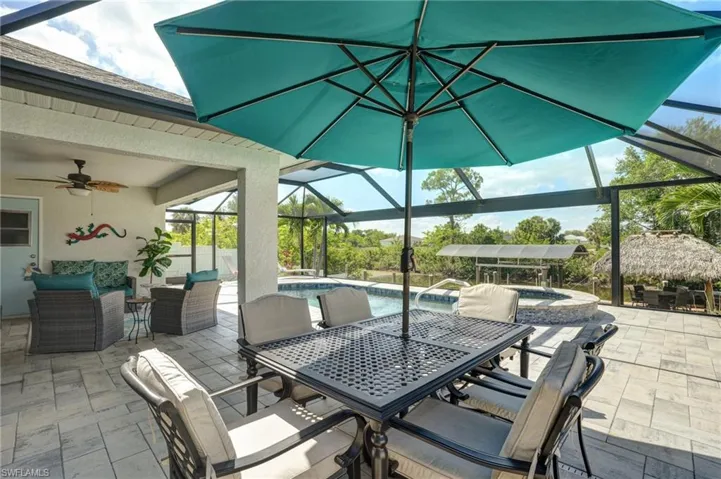 View of patio with outdoor dining area, ceiling fan, a lanai, and an outdoor hangout area