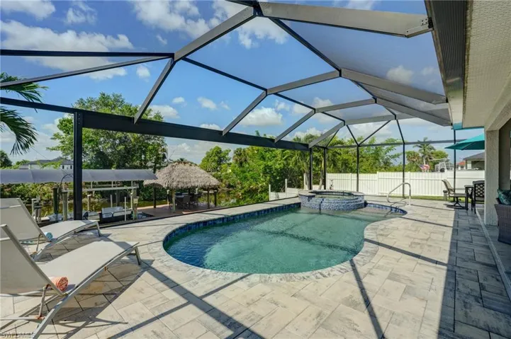 View of pool with a patio, a gazebo, a pool with connected hot tub, and a lanai