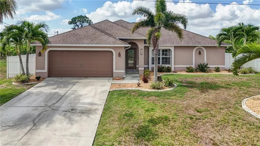 View of front of property with stucco siding, a garage, driveway, and a shingled roof