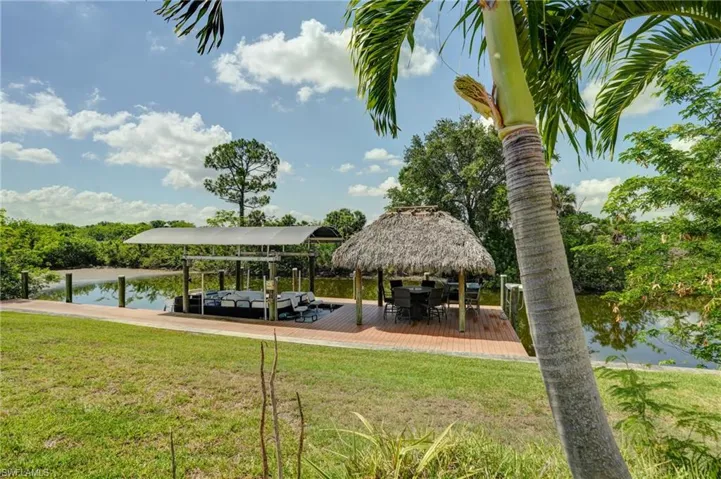 Dock area featuring a lawn, boat lift, a water view, and a gazebo