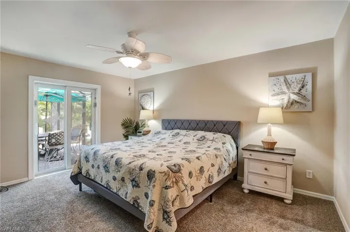 Carpeted bedroom with access to exterior, baseboards, and a ceiling fan