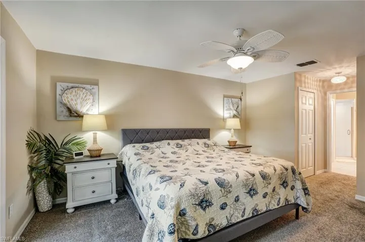 Carpeted bedroom featuring baseboards and ceiling fan