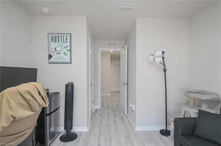 Corridor with light hardwood / wood-style flooring