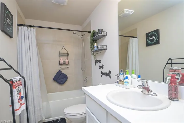 Full bathroom with vanity, toilet, and shower / bath combo with shower curtain