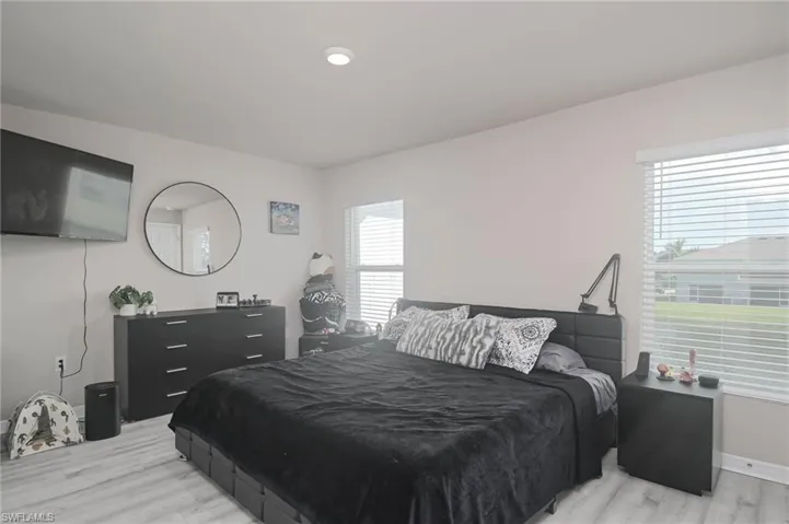 Bedroom with multiple windows and light hardwood / wood-style flooring