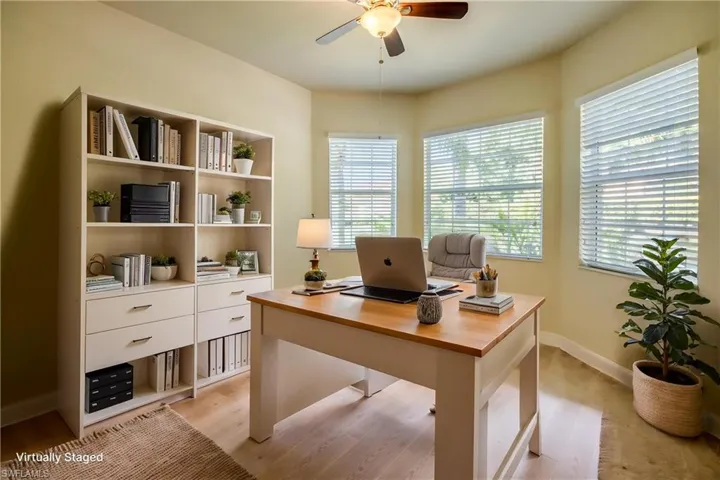 Office with light wood-style floors, plenty of natural light, and ceiling fan