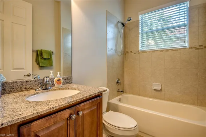 Full bath featuring bathing tub / shower combination, vanity, and toilet