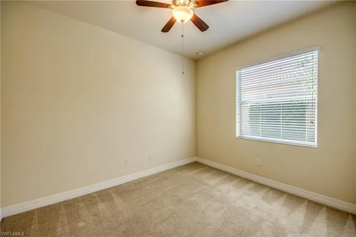 Empty room with ceiling fan, baseboards, and light carpet