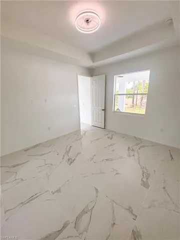Empty room featuring baseboards and marble finish floors