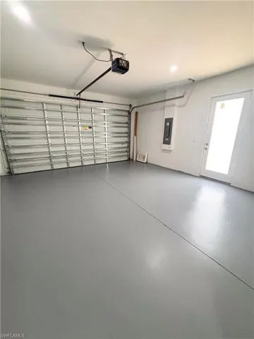 Garage featuring electric panel and a garage door opener