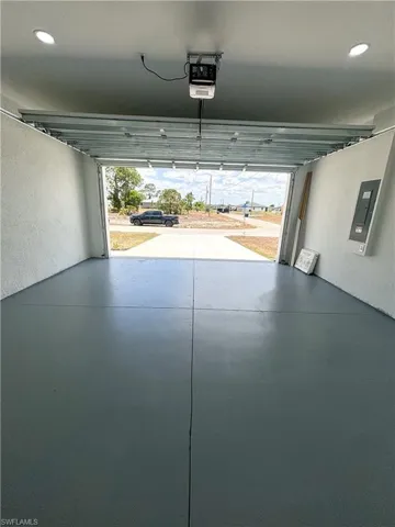 Garage featuring a garage door opener, electric panel, and recessed lighting