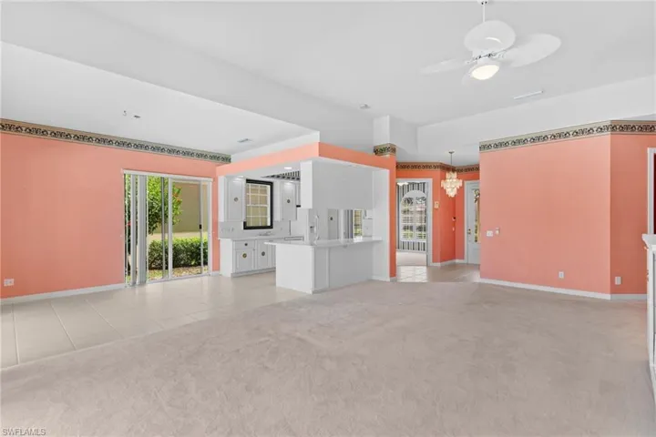 Unfurnished living room featuring ceiling fan, light colored carpet, and light tile patterned floors
