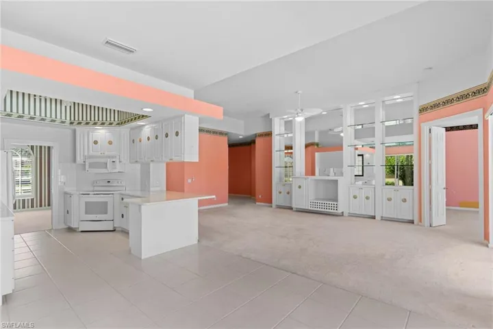 Kitchen featuring white cabinetry, plenty of natural light, light countertops, and white appliances